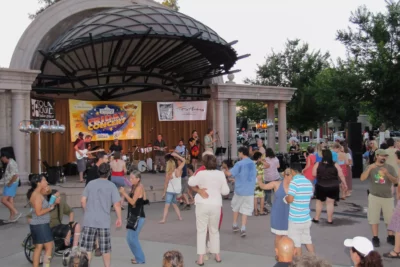 Los Papi Chulos performs for Friday Night Concert in Plaza Park in July 2011, as people dance and watch the band.