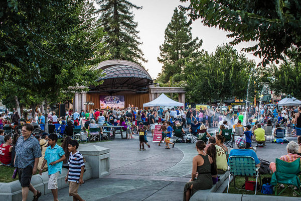 Plaza Park with band on stage and crowd in the plaza.